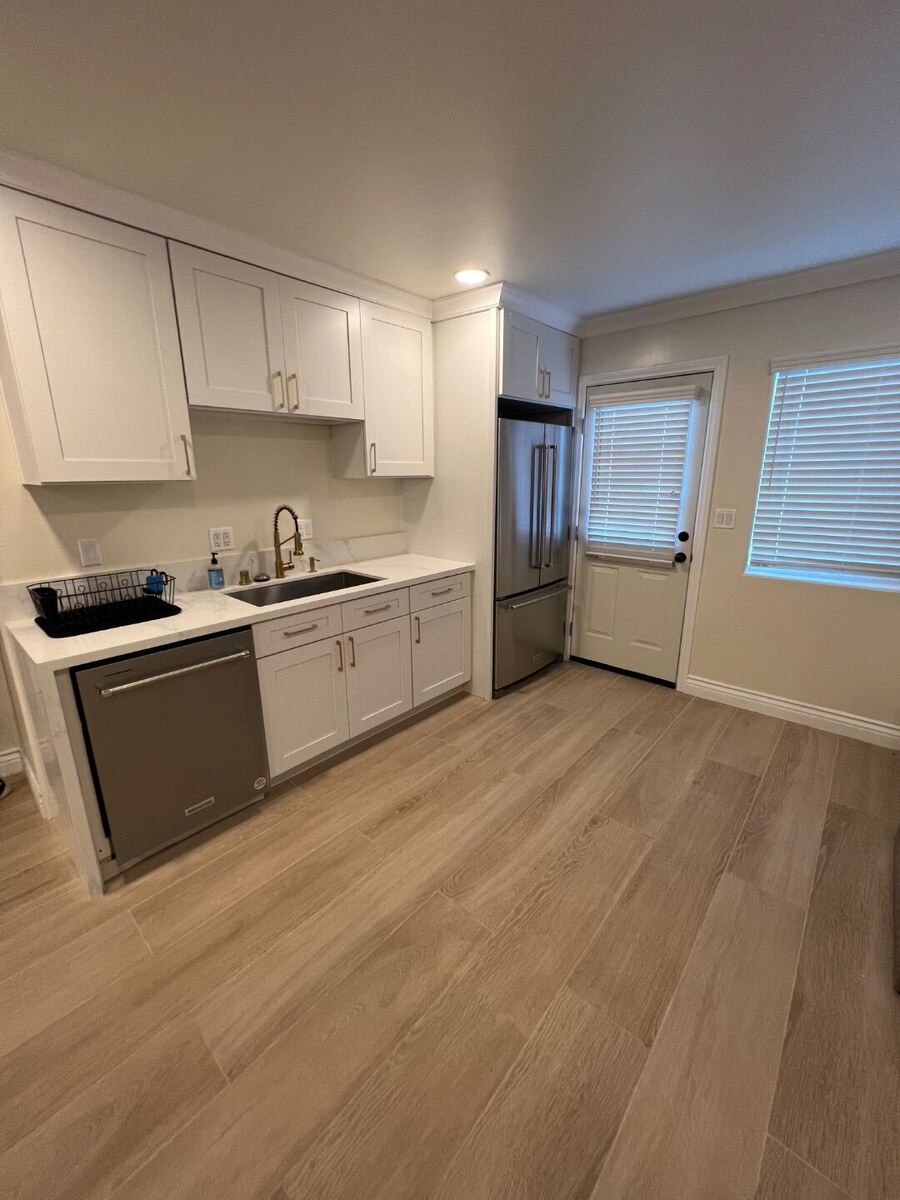 Kitchen with white shaker cabinetry, quartz counters, and stainless appliances