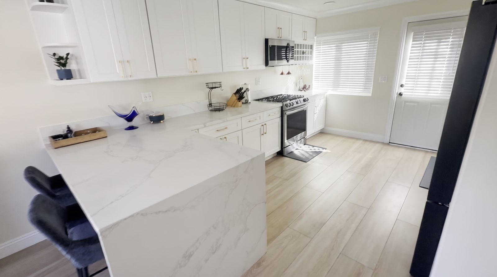 Full kitchen with gas range, stainless appliances and quartz counters at Her Aria recovery residence, Montclair CA